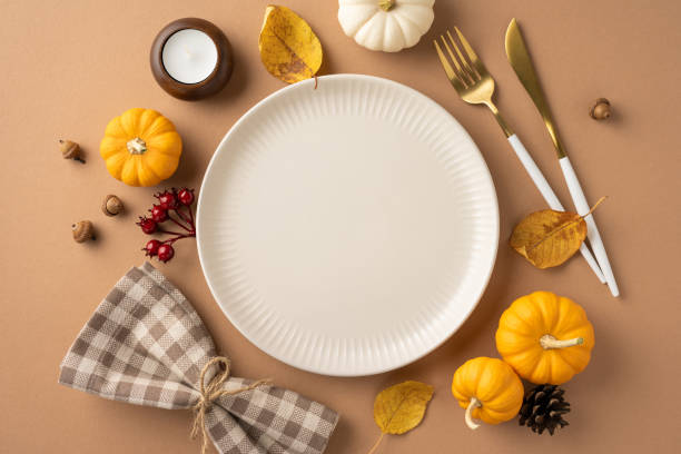 istock A festive Thanksgiving table setting featuring a plate, pumpkins, leaves, and elegant cutlery, evoking seasonal warmth and celebration 2174905629
