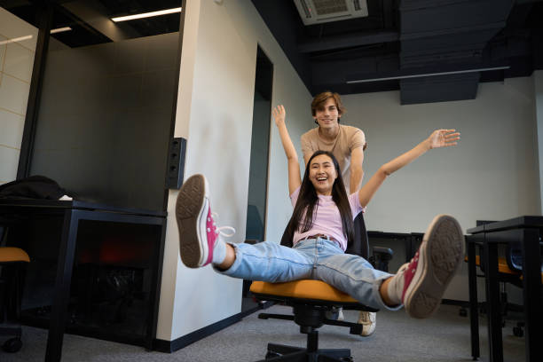 istock Young man is pushing his girlfriend in an office chair 2174905860