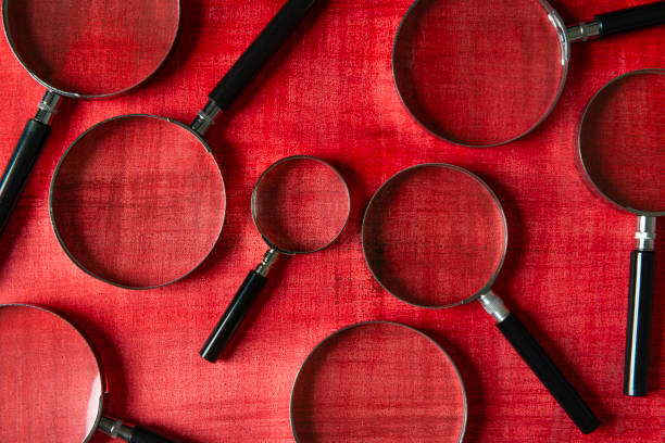 The magnifying glasses of varying sizes offer a dynamic and striking visual, symbolizing investigation, research, and close examination. This image is perfect for themes related to inquiry, attention to detail, research, and discovery.