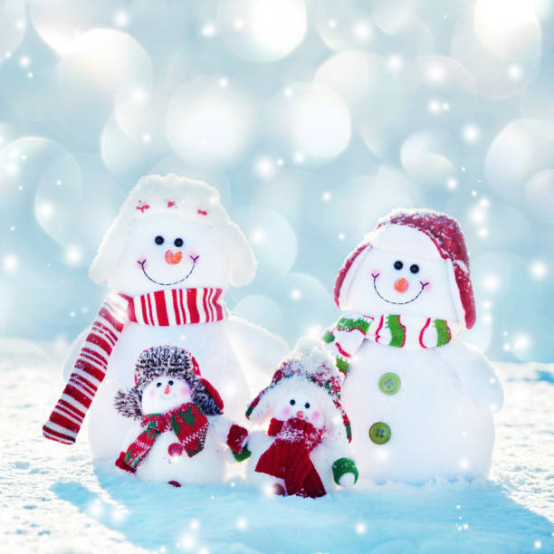 Family snowmans on snow. Mother, father and children at winter