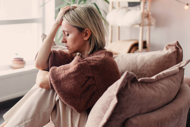 istock Frustrated Sad Woman sitting on Couch at Home 2174907429