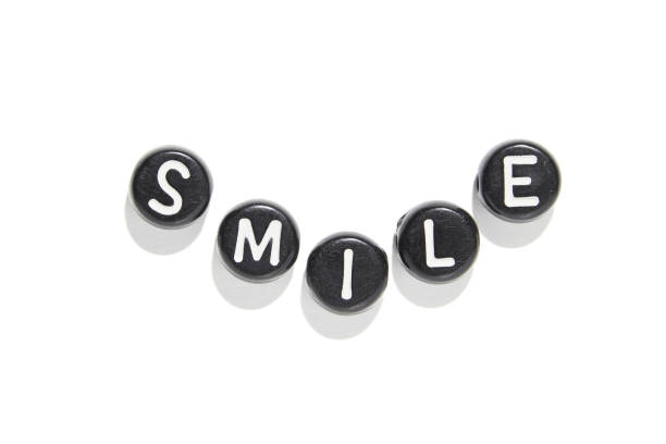 istock Black and white letter beads arranged to spell smile on white background 2174908276