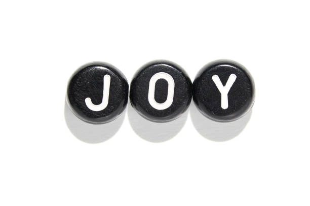 istock Black circular objects spelling joy on white background for positive emotional 2174908291