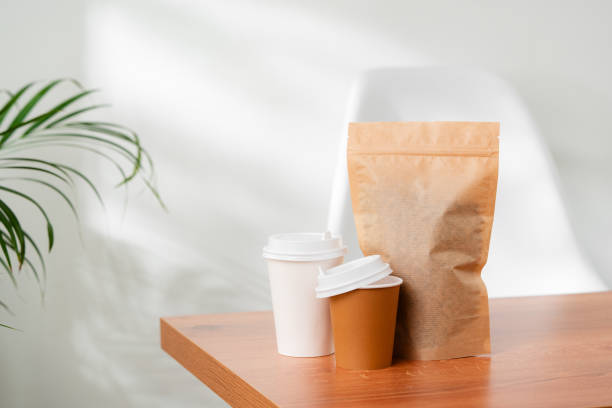 istock Three beverage containers and a paper bag on a wooden table 2174911695