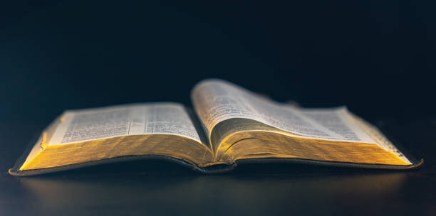 istock Open Bible on a black background. Religion concept. 2174914013