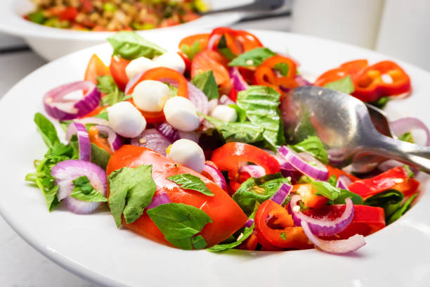 istock Green Salad with Fresh Tomatoes, Bell Peppers, and Onions - Side View 2174915103