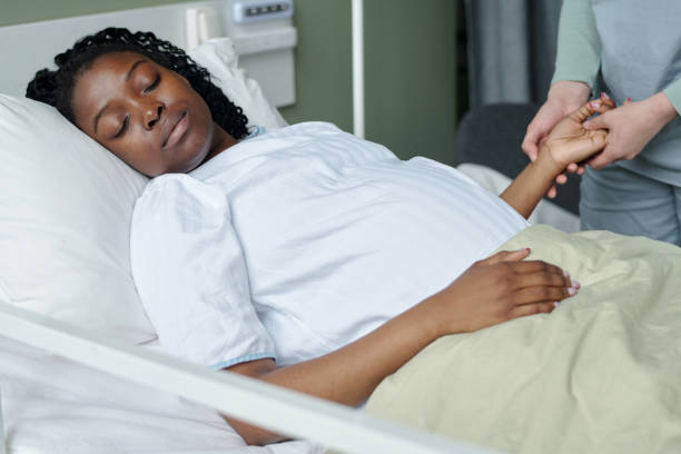 istock Caring Nurse Holding Patient's Hand in Hospital Bed 2174918021