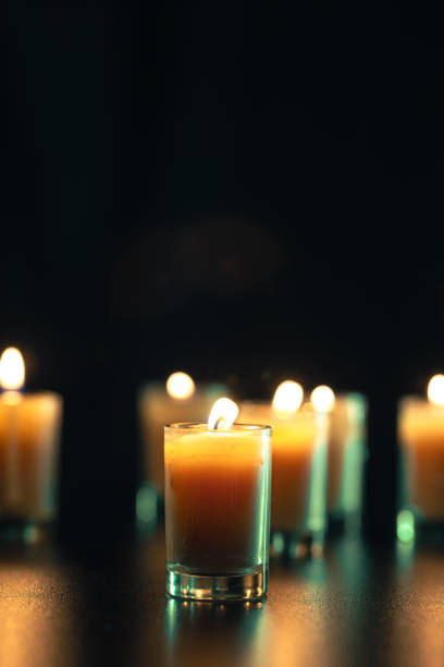 istock Burning candle on black background with backlight. Memorial Day. 2174918357