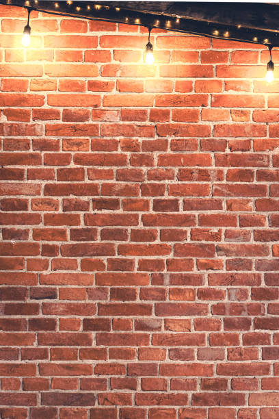 istock Lights garlands hanging from red brick wall at evening. 2174919385