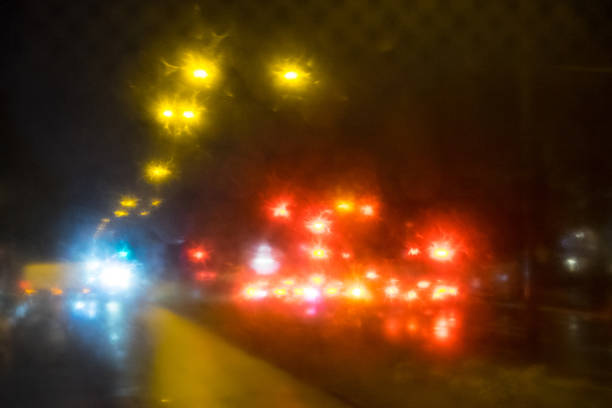 Reflections of night lights through a glass, on a rainy day