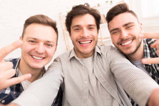 istock Friends making selfie, gesturing rock and roll sign 2174923859