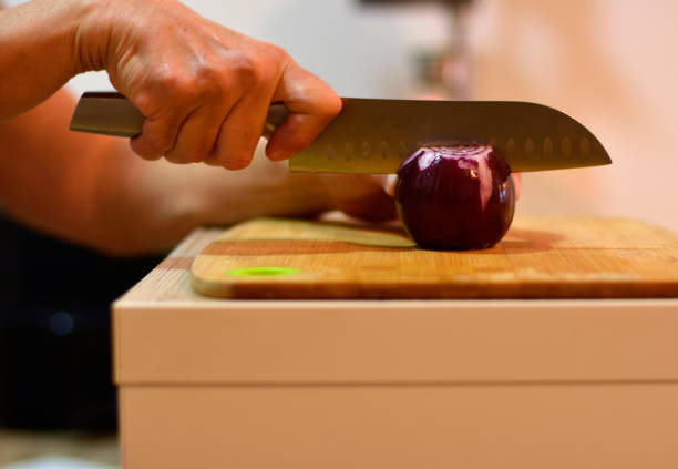 Closeup portrait of a male chef cook sharpening knife isolated on a white background