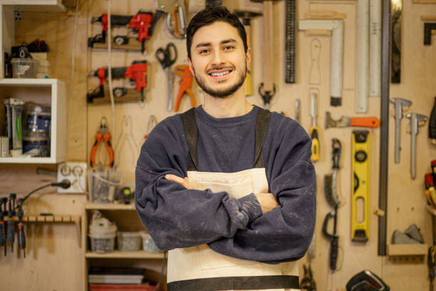 istock portrait of positive smiling carpenter at work place 2174926691