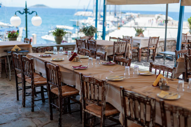 istock Long table set for dinner at a greek restaurant with an ocean view 2174927571