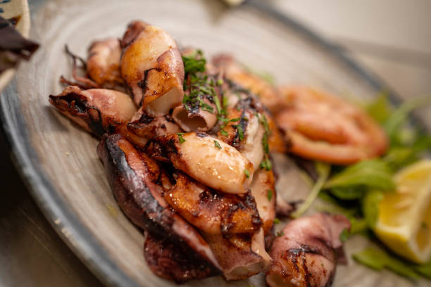 Grilled squids on the plate close up