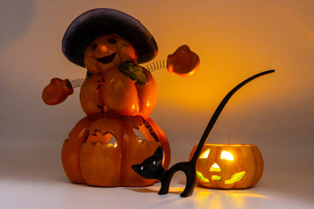 Jack O Lantern and and a black cat figurine. Ceramic candle holder in the shape of a halloween pumpkin. Candle lit in a Jack O Lantern. Cute halloween display