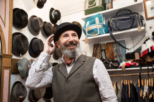 istock Senior man trying on a hat in a vintage clothes store 2174934957