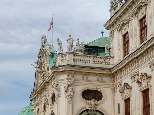 Belvedere Baroque palace in Vienna seen from the public gardens with fountains and dark clouds above.