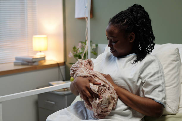 istock Cradling Newborn in Hospital Bed with Soft Lighting 2174937771