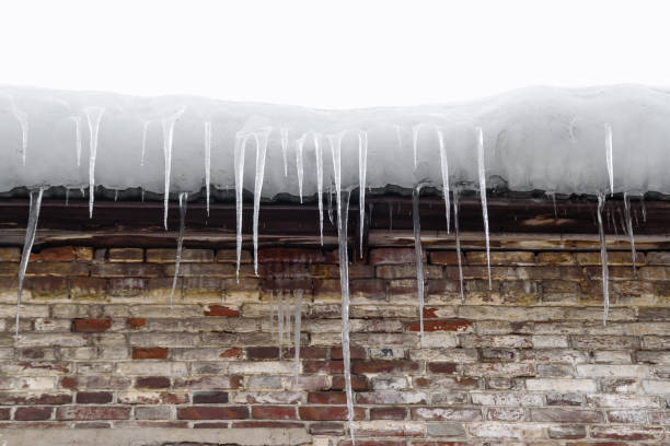 icicles on roof of old brick low-rise building, danger to pedestrians