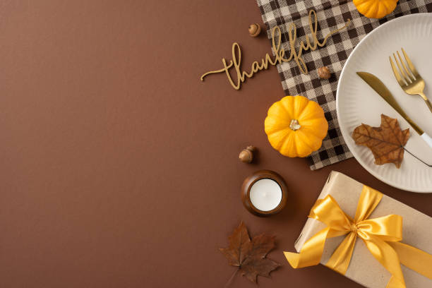 istock Festive Thanksgiving table setting featuring pumpkins, a gift box with ribbon, cutlery, and cozy autumn decor for a warm celebration atmosphere 2174946314