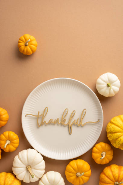 istock Top vertical view of Thanksgiving table setting with small pumpkins and a plate featuring the word thankful, conveying autumn gratitude and celebration 2174946324