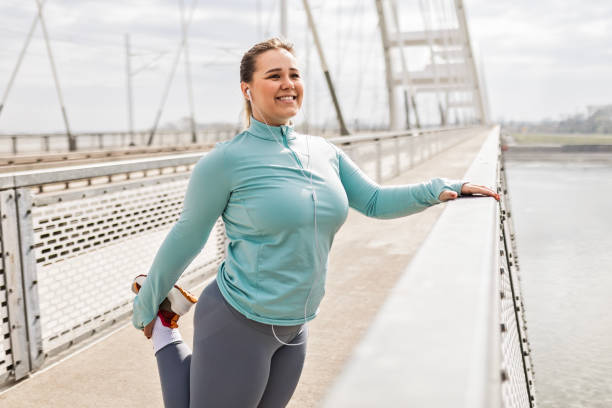istock Overweight young woman exercising on bridge 2174947031