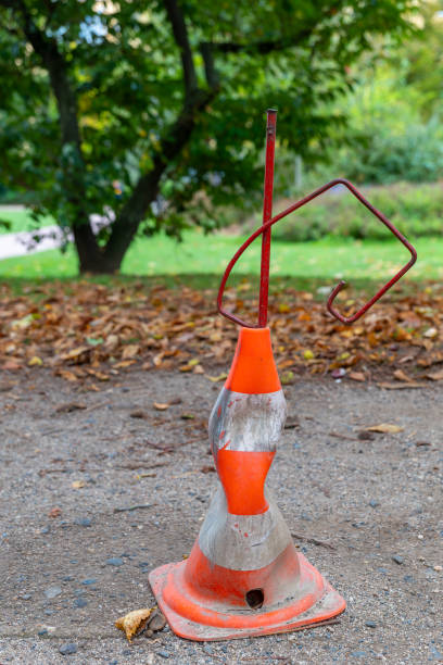 istock bent orange and white cone is on the ground 2174947032