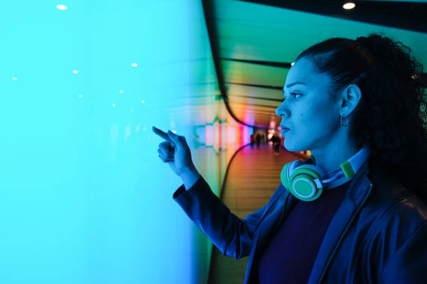istock Young woman using interactive touchscreen in futuristic tunnel 2174951662