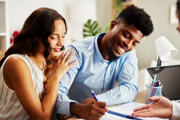 istock Young couple signing a contract with an agent in the office 2174969257