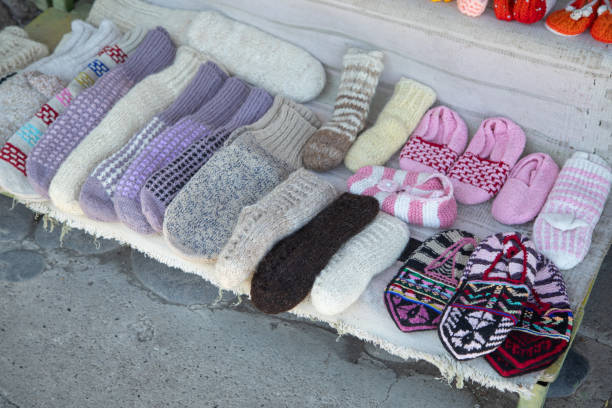 Cozy knitted socks peek out from beneath soft blankets, creating a tender scene of comfort and security. The warmth of home and the gentle textures evoke a feeling of protection and peace, a quiet refuge from the world. Copy space for text, high angle view - Autumn, lifestyle