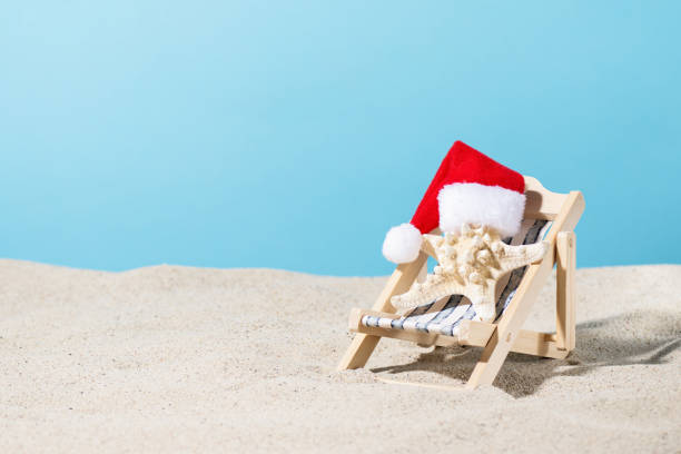 istock Starfish in Santa hat on sand beach over blue background. 2174979982