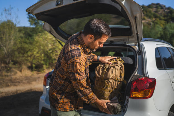 istock Adult man prepare backpack to pack into trunk in outdoor wilderness 2174996820