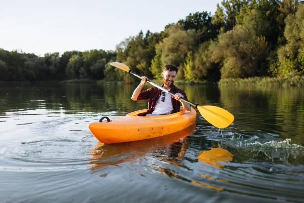 istock Cheerful Handsome Man Rowing Kayak at Sunset 2175012423