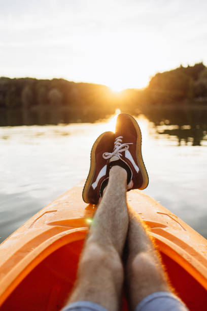 istock Man Relaxing on a Kayak, Stretching His Legs at Sunset 2175013303