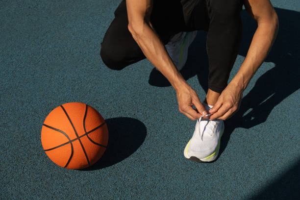 istock Basketball player tying running shoes shoelace before training. 2175031499