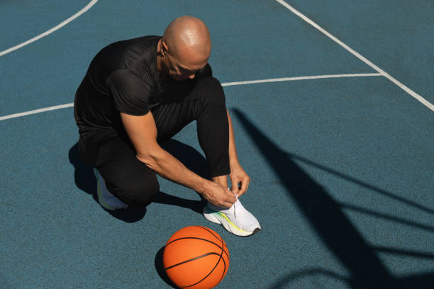 istock Basketball player tying running shoes shoelace before training. 2175031508