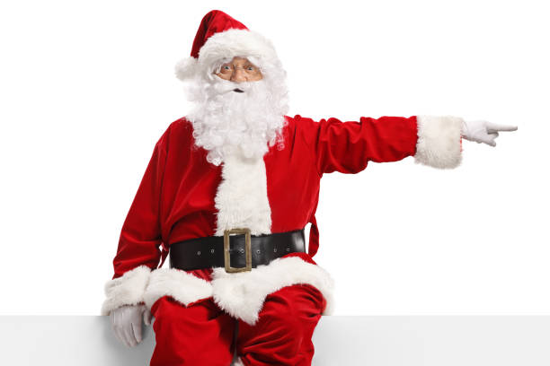 istock Santa claus sitting on a blank white banner and pointing 2175034253