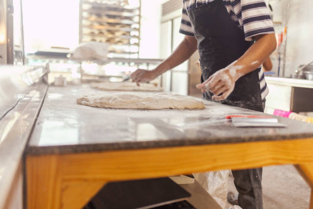 istock Unrecognizable baker kneads the dough in the bakery 2175034467