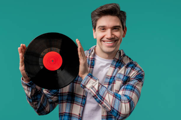 istock Handsome man dancing vinyl record disc on blue. Hobby, music lover, collection 2175042976