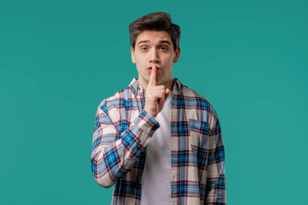 istock Handsome man with gesture shh, secret, silence, conspiracy, gossip on blue 2175042980