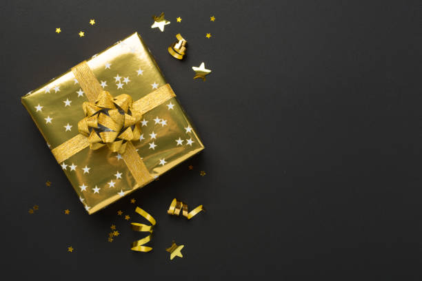 istock Golden gift boxes and confetti on color background, top view 2175044165