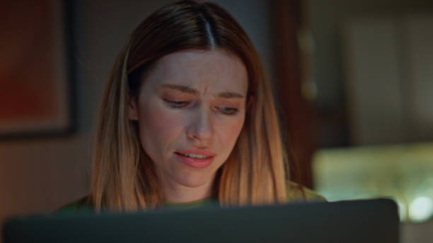 istock Stressed girl talking online conference by computer in dark home close up. 2175045152