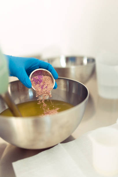 Unrecognizable woman with protective gloves making natural soap