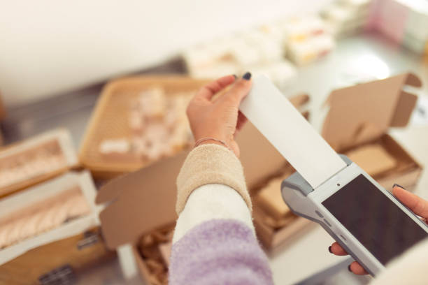 istock An unrecognizable woman uses a POS terminal to charge a customer for an ordered package, small business concept 2175049952