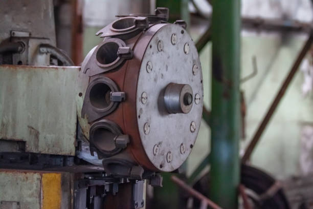 A rotating cylinder used in industry. It shows numerous clamps holding metal parts that can be inserted through holes in the cylinder, indicating a mechanical or manufacturing process