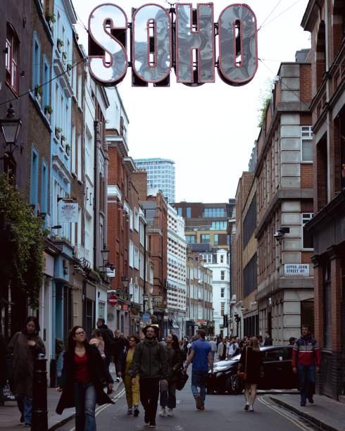 London, England, Apr 30 2023: Carnaby Street street view with a Soho sign and people walking around