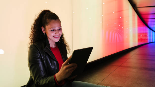 istock Young woman using tablet in colorful tunnel 2175058160