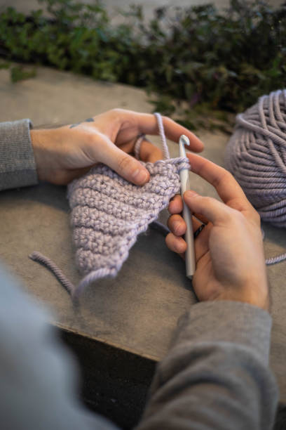 istock Man hands crochets handmade crocheting supplies assorted wool yarn hook knitting top view closeup 2175067344