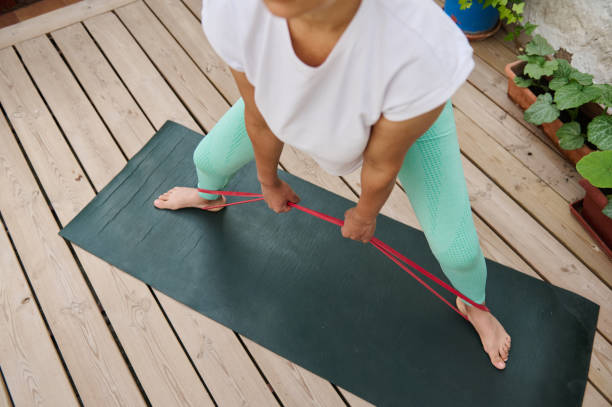 istock Woman practicing resistance band exercise on yoga mat outdoors for strength and flexibility training 2175075016